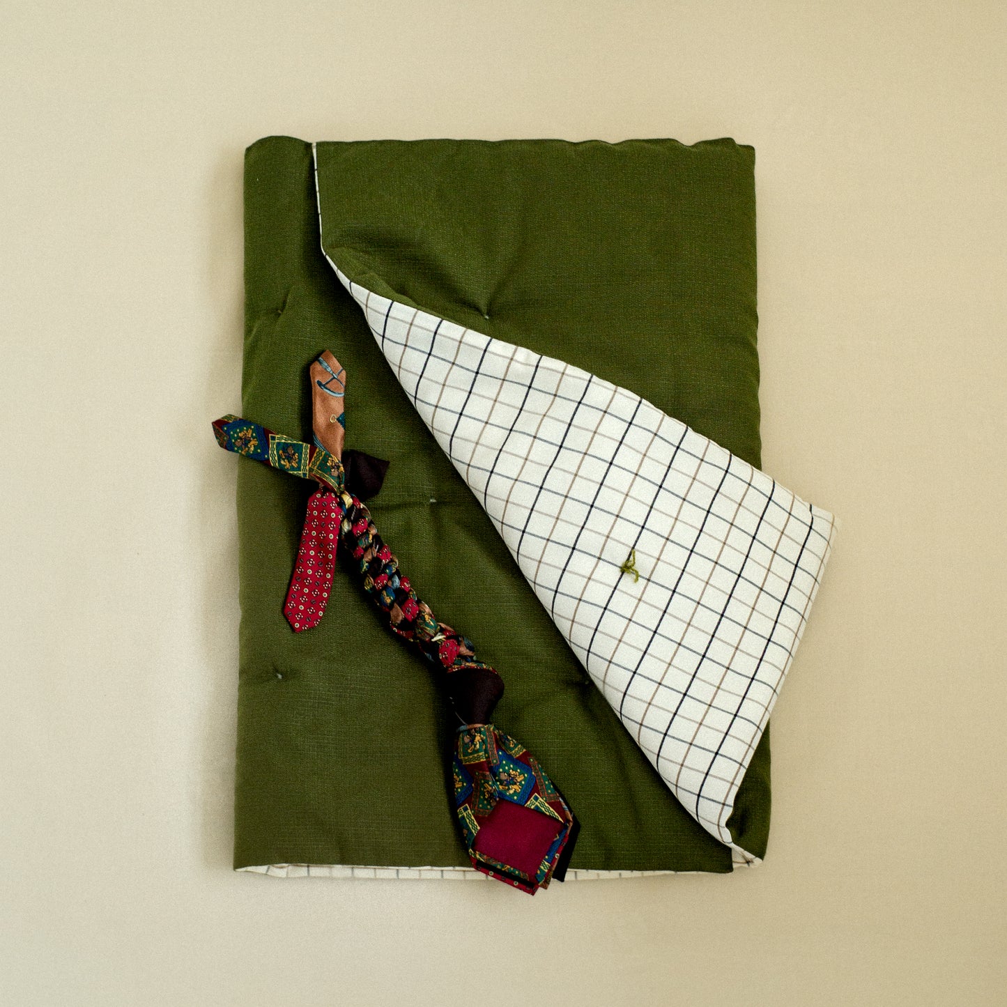 Colorful vintage tie tug toy for dog on bed throw