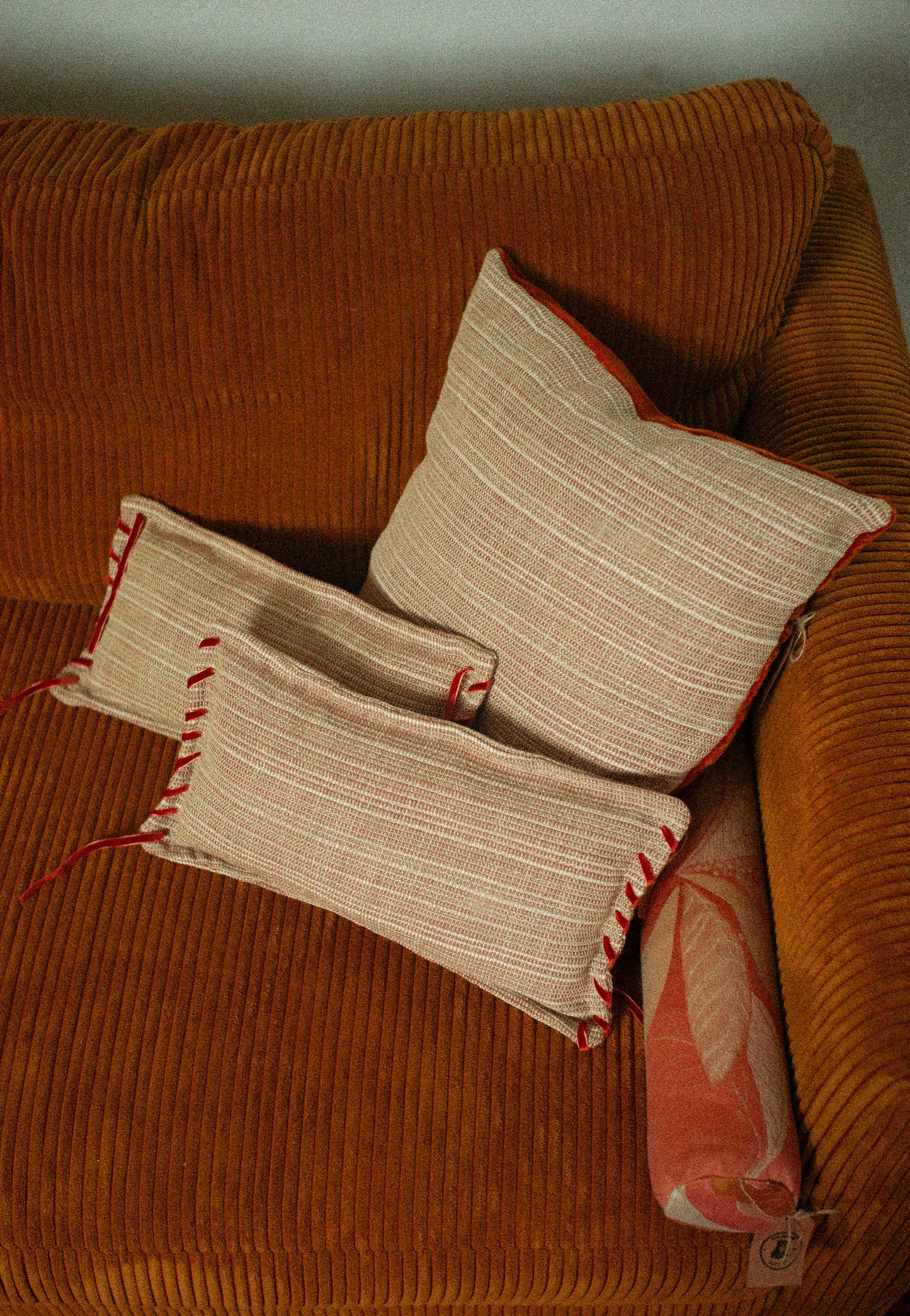 Three patterned pillows on a brown couch
