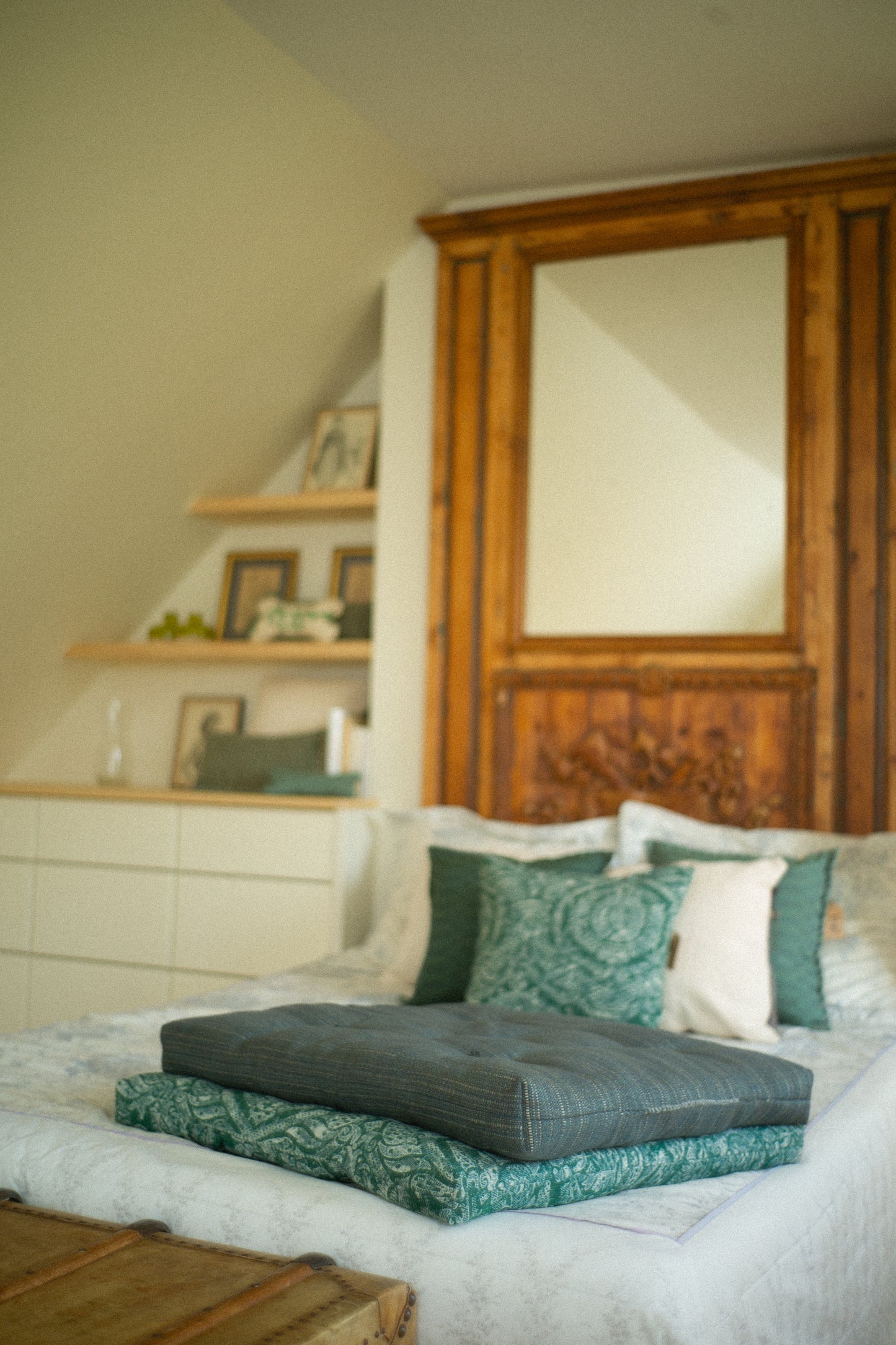 Bedroom with dog beds and decorative pillows, wooden cabinet, and shelves.