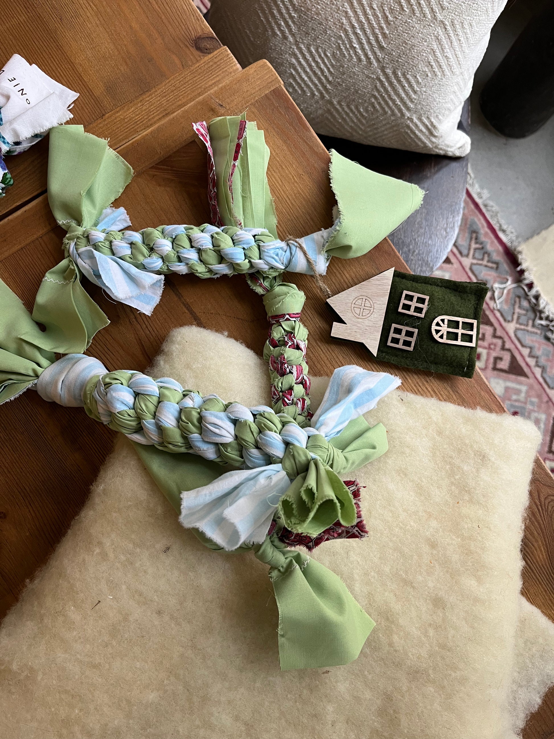 Dog toy with braided rope and fabric pieces on a wooden surface