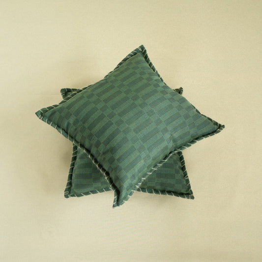 Two green patterned pillows on a beige background