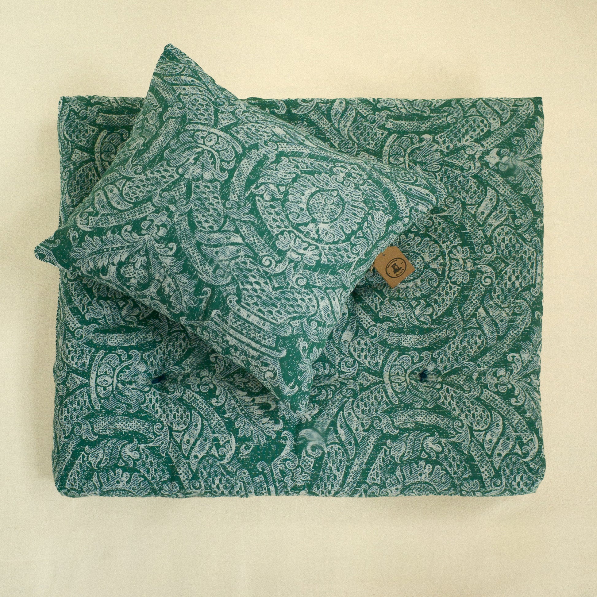 Green paisley patterned fabric decorative cushion and matching dog bed