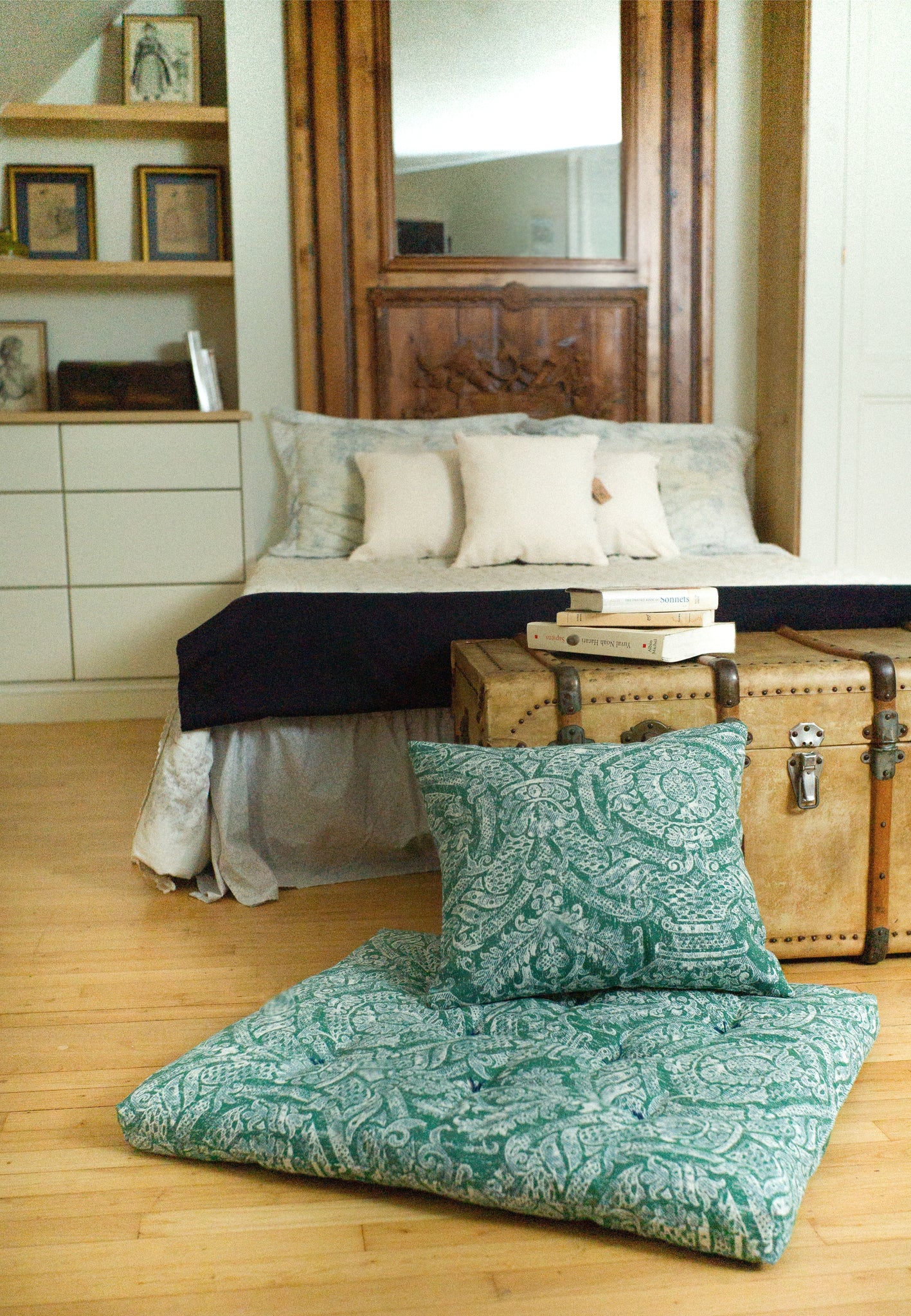 Green paisley patterned fabric dog bed or playmat for kids on a wooden floor with a bed