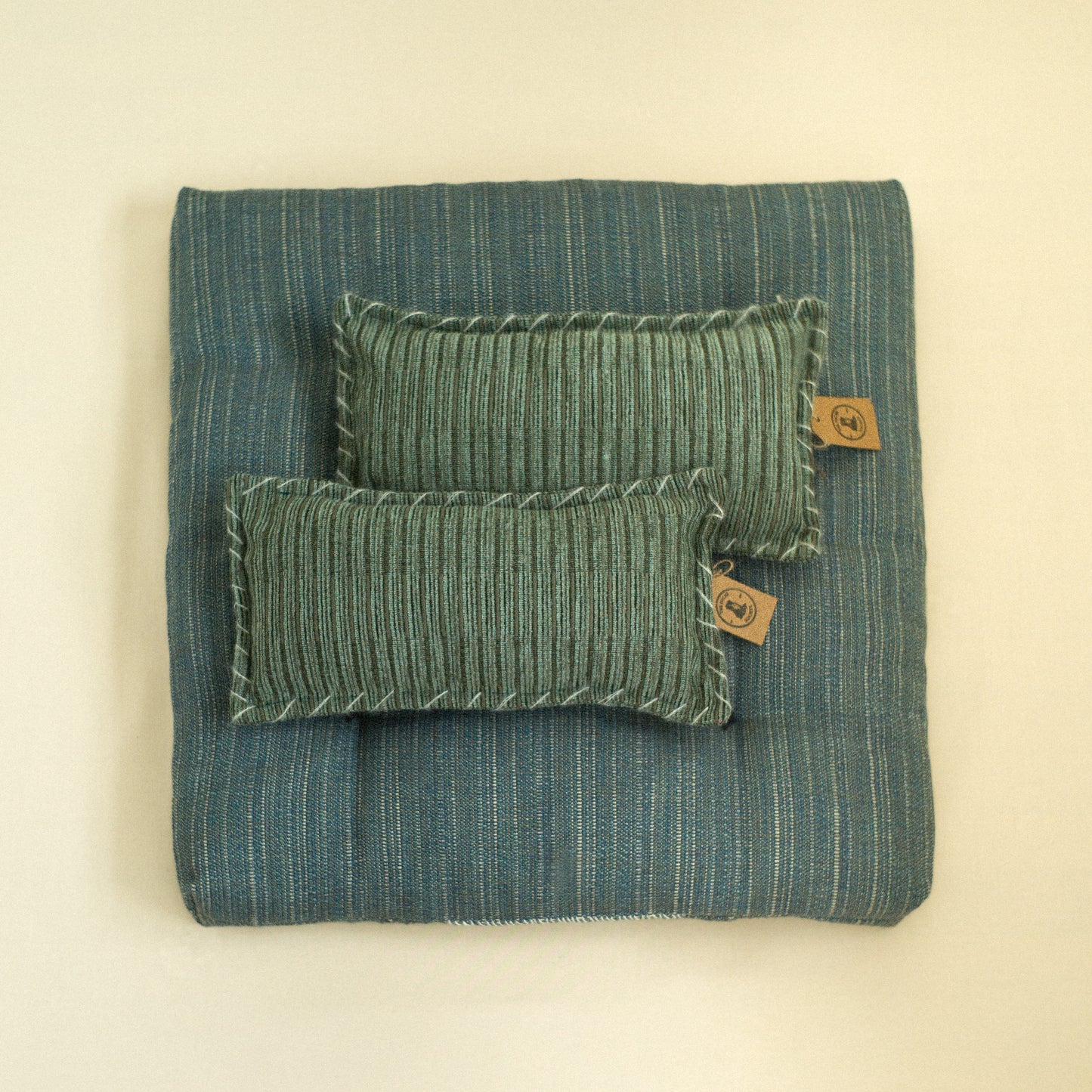 Teal textured dog bed with quilted detail filled with sheep wool with cushions.