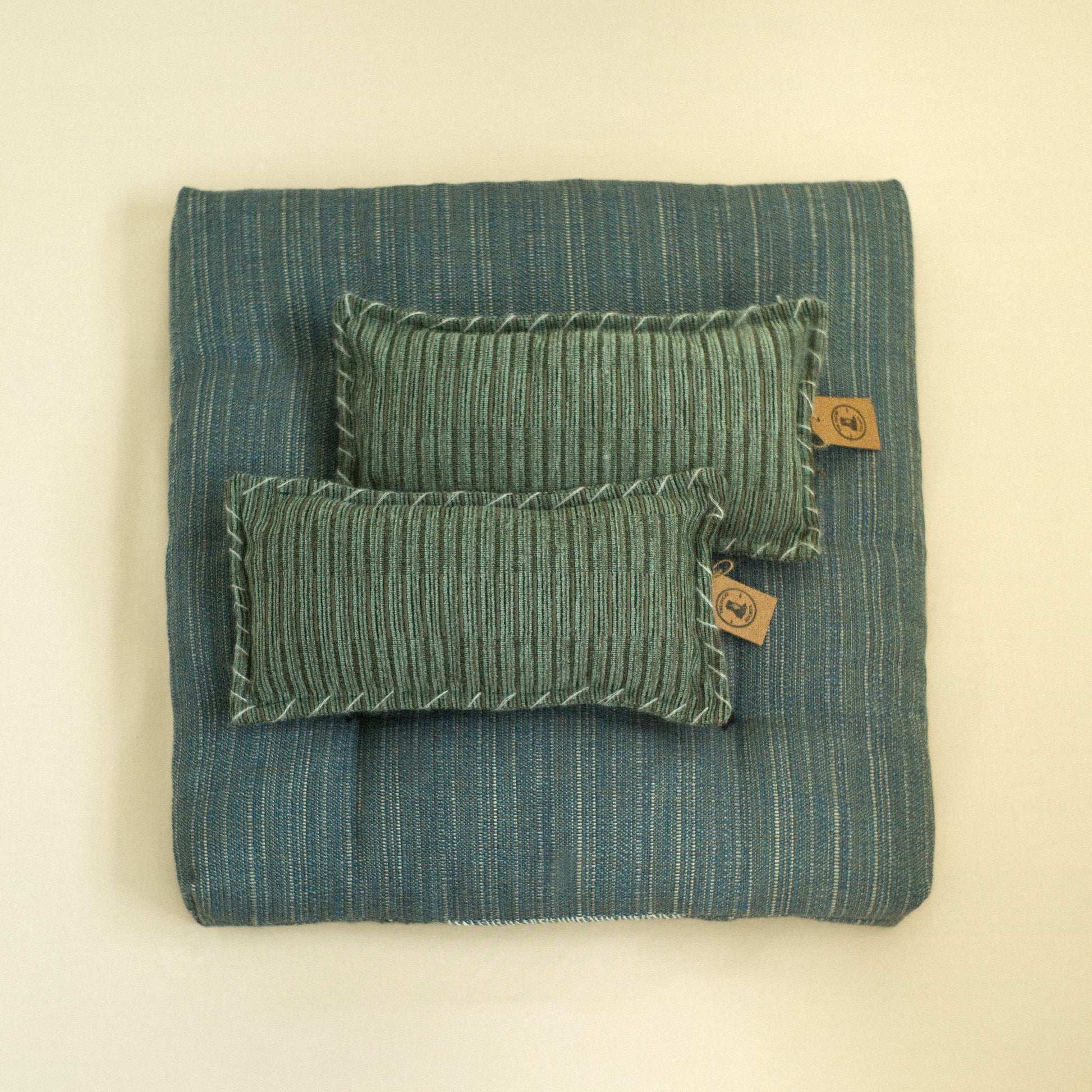 Teal textured dog bed with quilted detail filled with sheep wool with cushions.