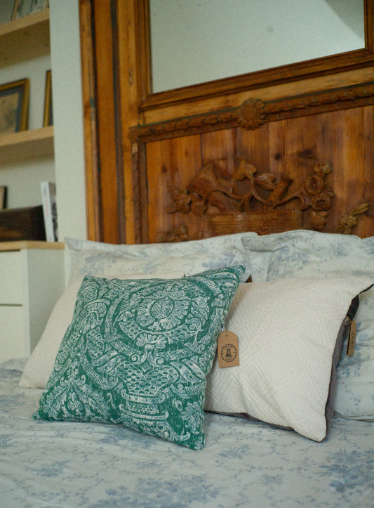 Decorative pillows Perennials Sutherland rosemary fabric on a bed with a wooden headboard