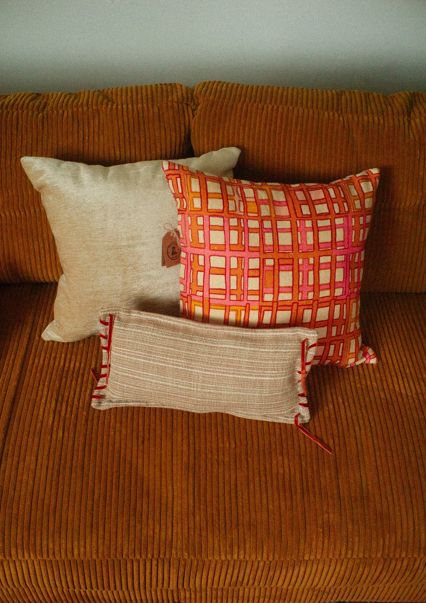 Three pillows on a brown textured sofa