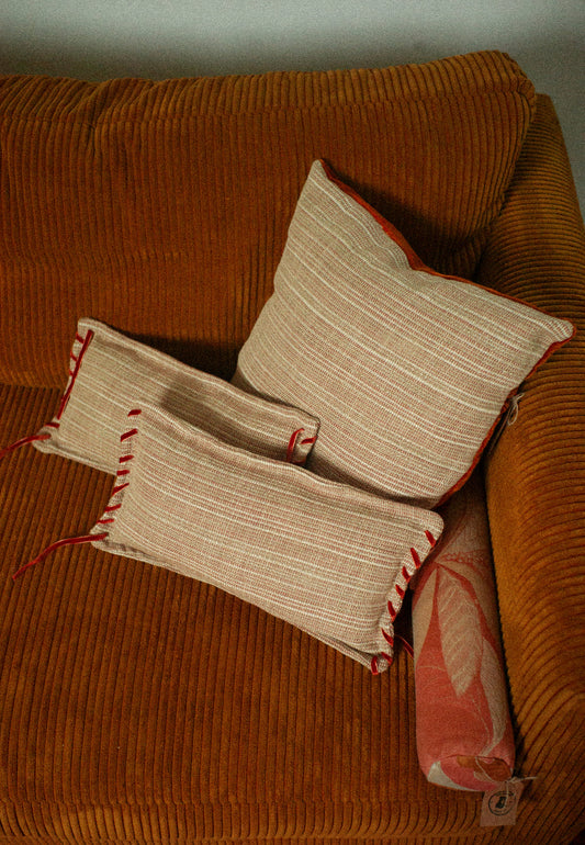 Three patterned pillows on a brown couch