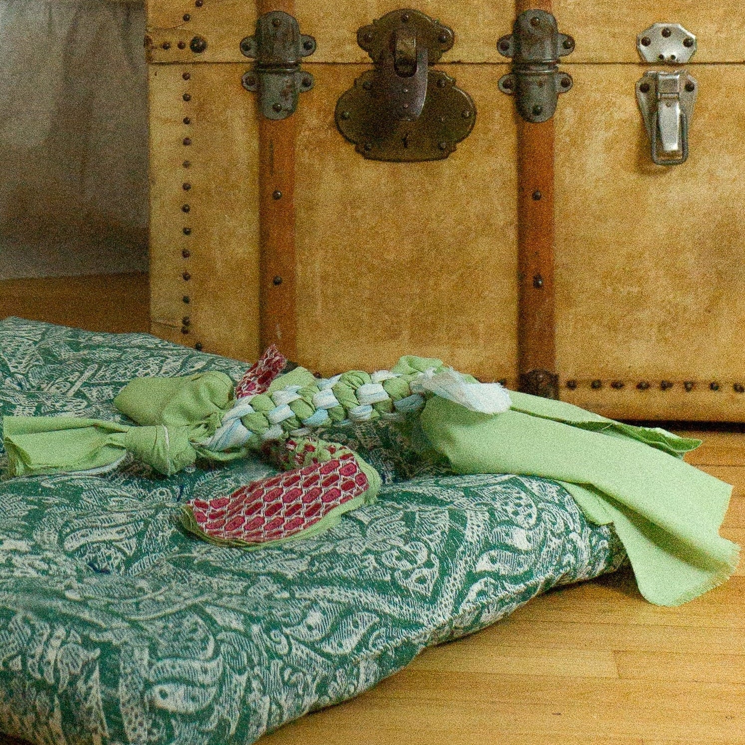 Room interior with a bed, vintage trunk, and decorative pillows.