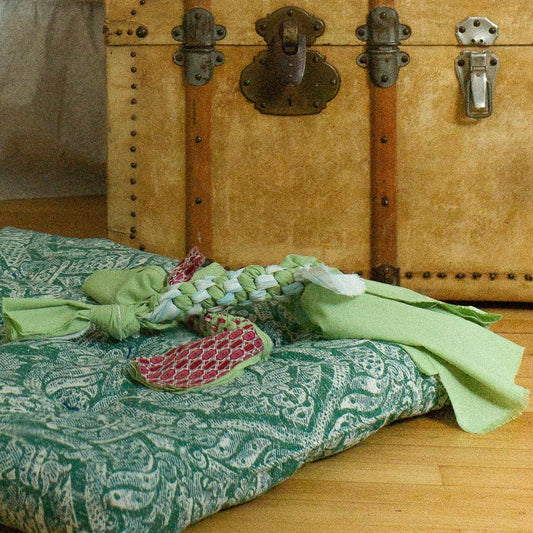 Room interior with a bed, vintage trunk, and decorative pillows.